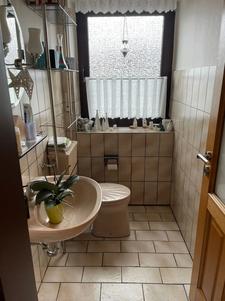 Kleines Badezimmer vor der Sanierung – alte Fliesen